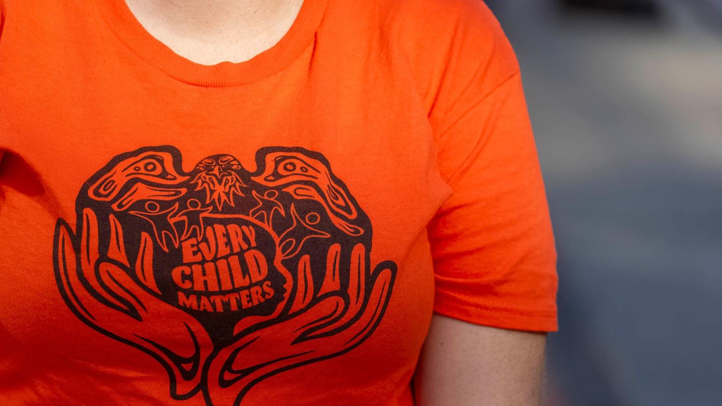 person wearing orange shirt with the slogan every child matters