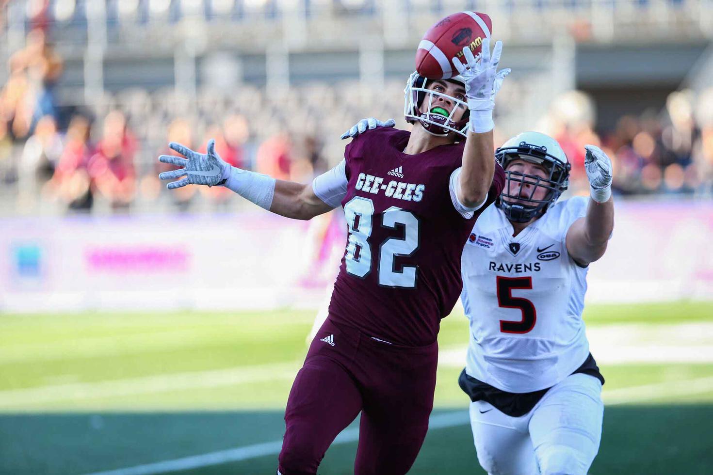 Un joueur de football de l’Université d’Ottawa attrape le ballon d’une seule main.