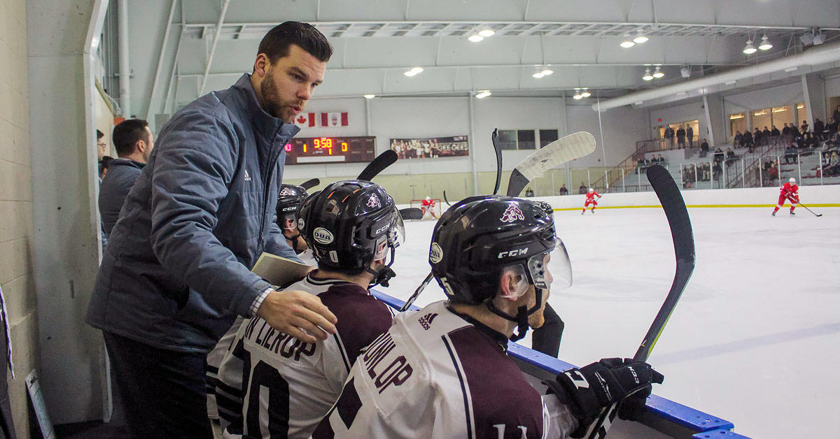 Brent sullivan with players ont the bench.