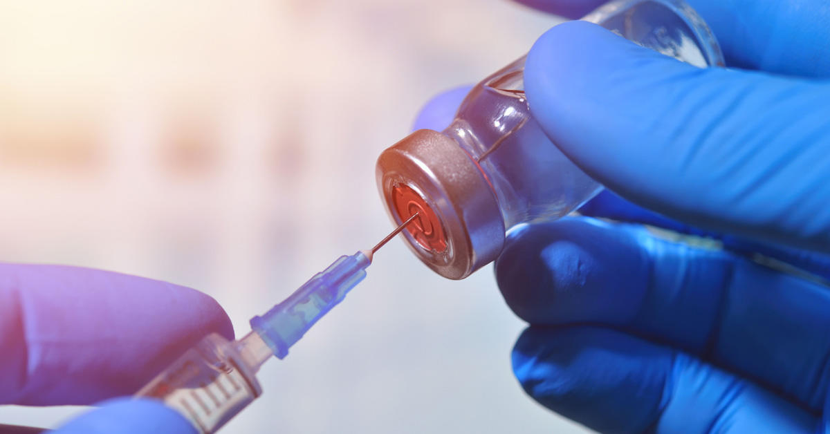 Une seringue insérée dans une fiole de vaccin.
