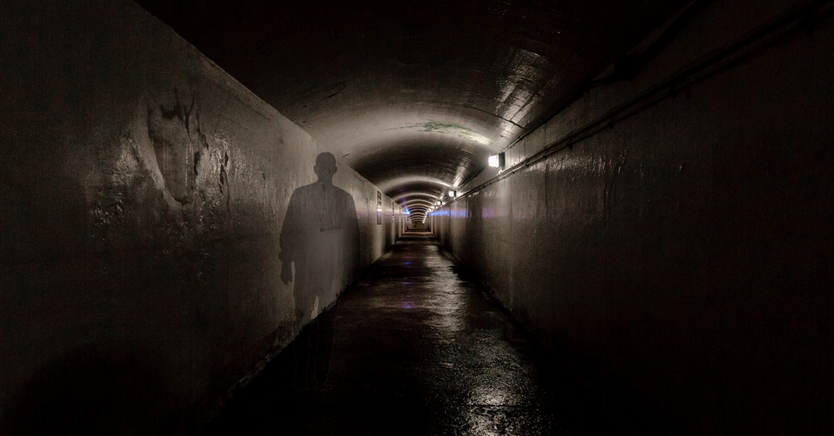 Un tunnel avec l'ombre d'un homme projeté sur le mur.