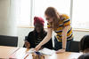 Student mentor helping fellow student with assignment.