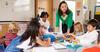 Children playing in a classroom with their teacher