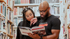 authors reading the trailblazers book they created in a library setting