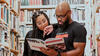 authors reading the trailblazers book they created in a library setting