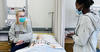 Two nursing students talking to each other in the lab.