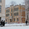 People walking on campus as snow is falling.