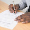 Person filling out application form.