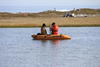2 researchers in a boat on a lake