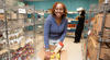 A smiling woman organizing food donations in a community pantry