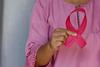 Close up on hands holding a pink ribbon