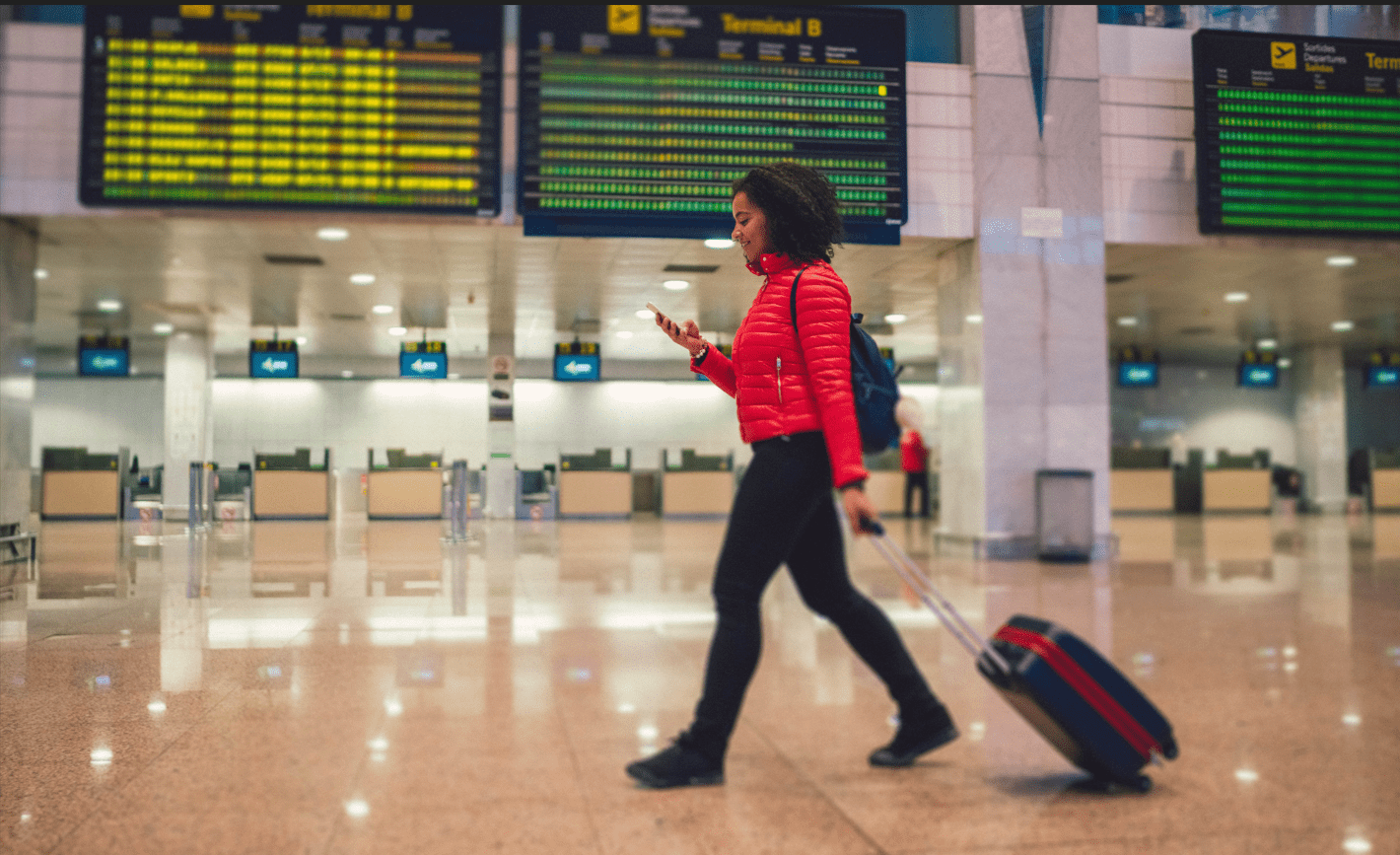 Young woman with a suitcase walking through an airport
