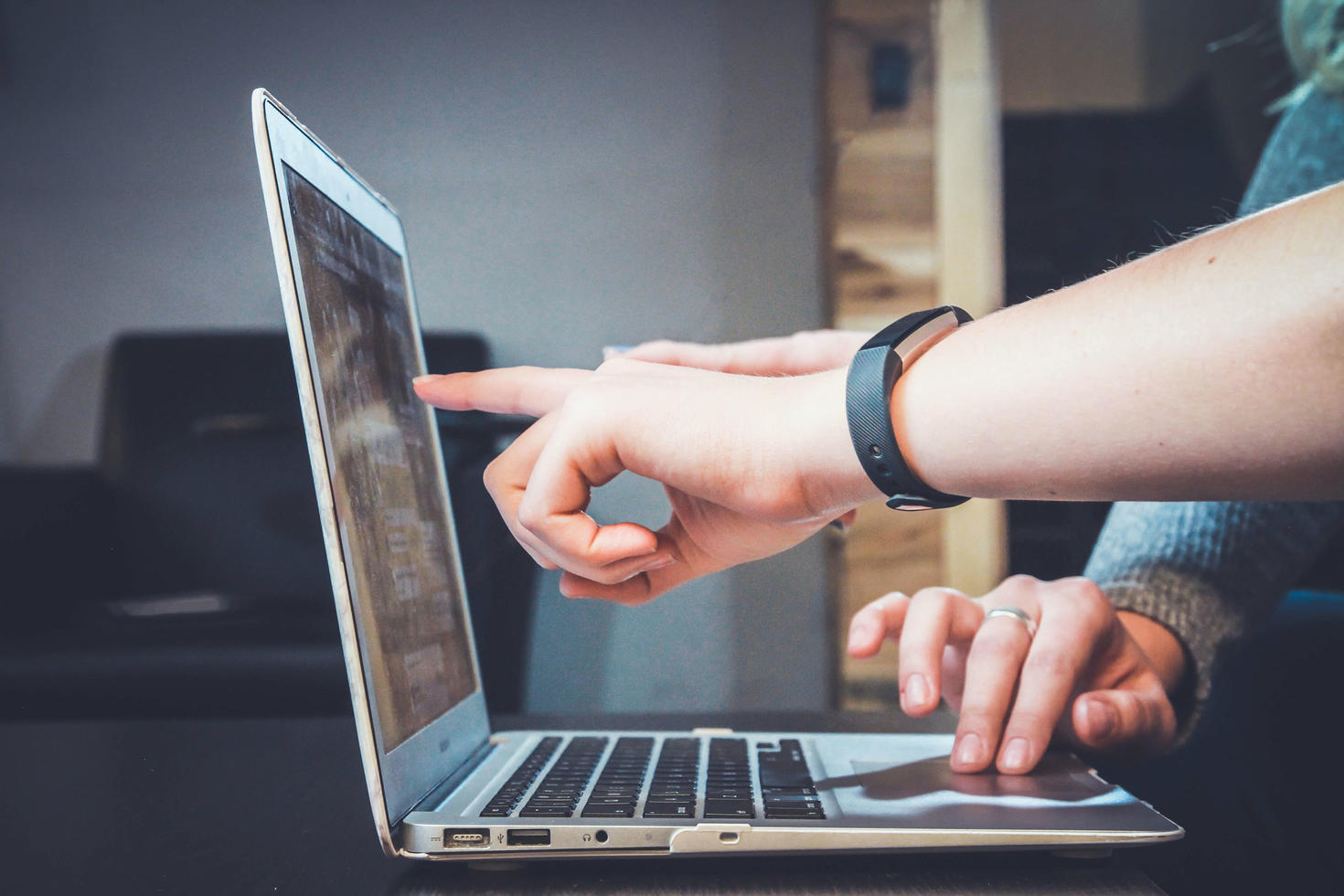 Person pointing at computer screen.