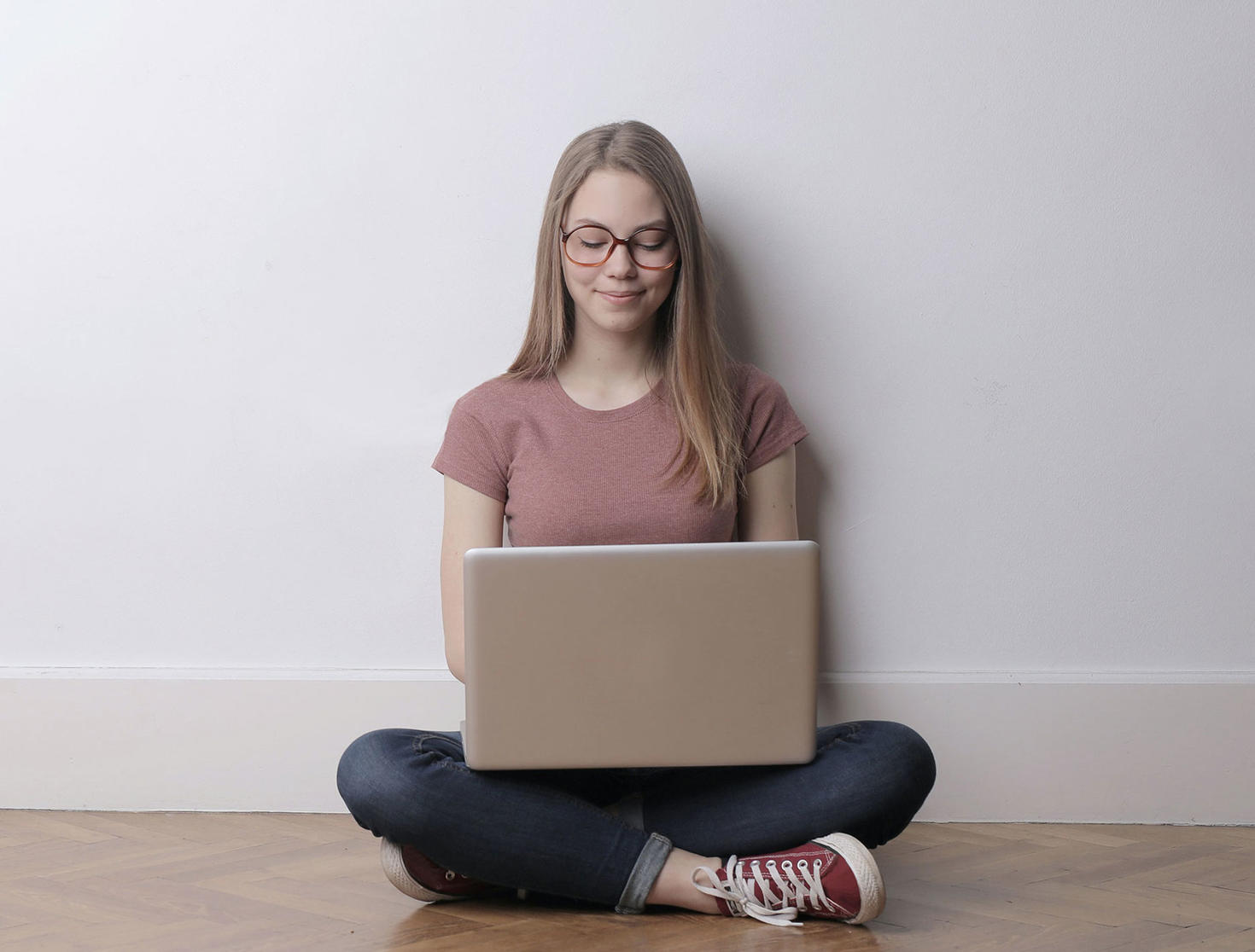 student sitting on floor using laptop