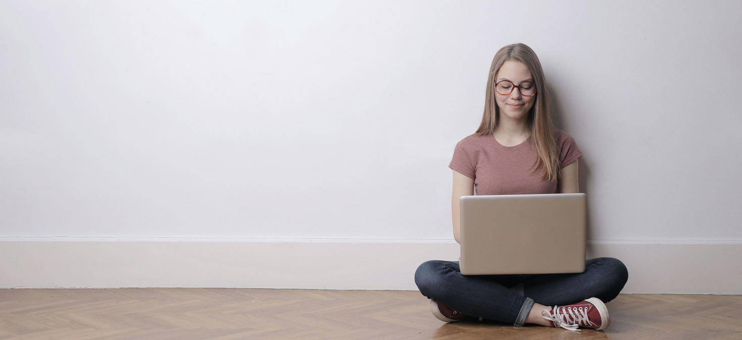student sitting on floor using laptop