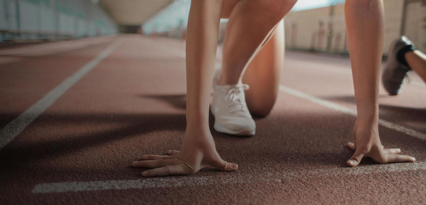 close up of runner's hands and feet on start line