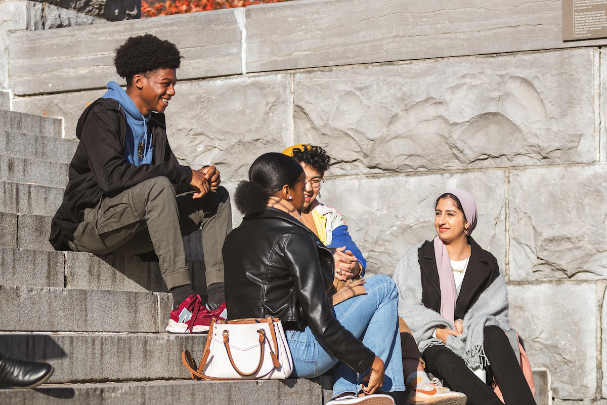 Students chatting on the steps of Tabaret Hall.