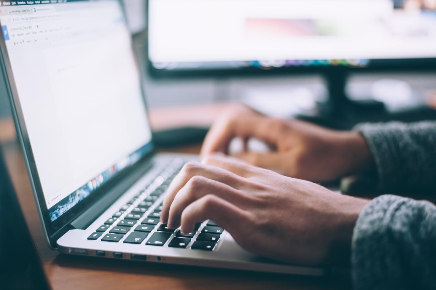 Person typing on laptop.