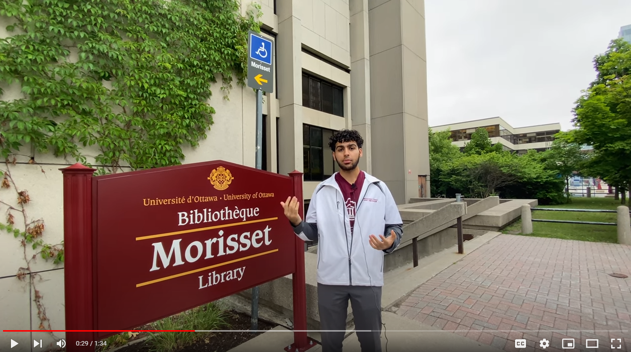 student in front of library