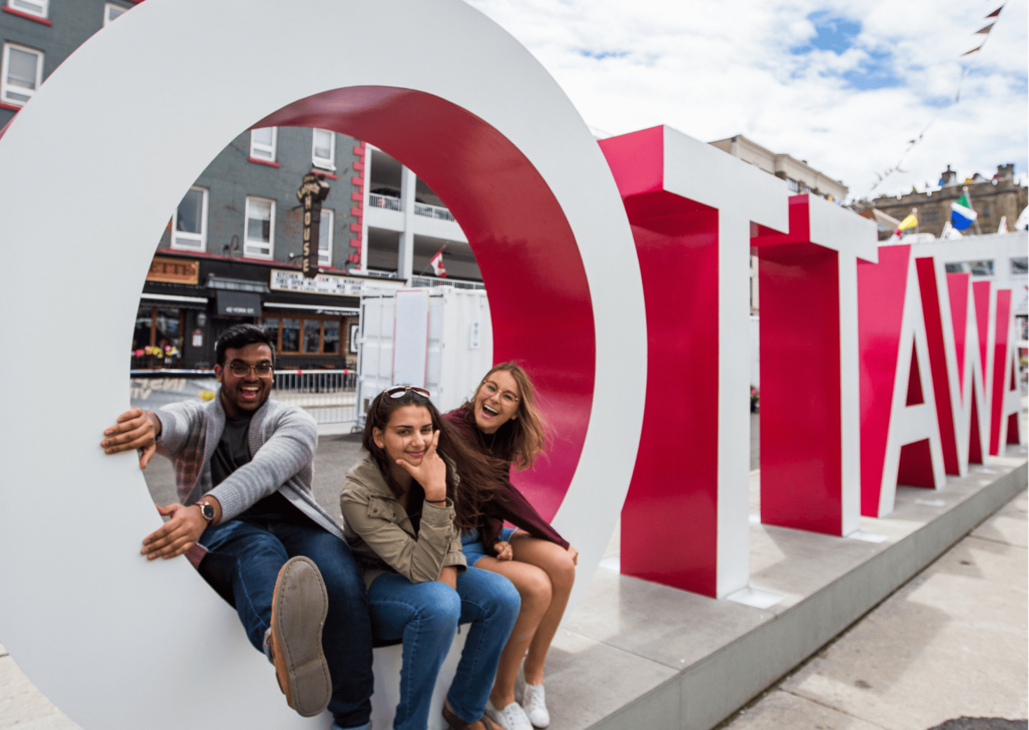Three students at the Ottawa sign in the ByWard market