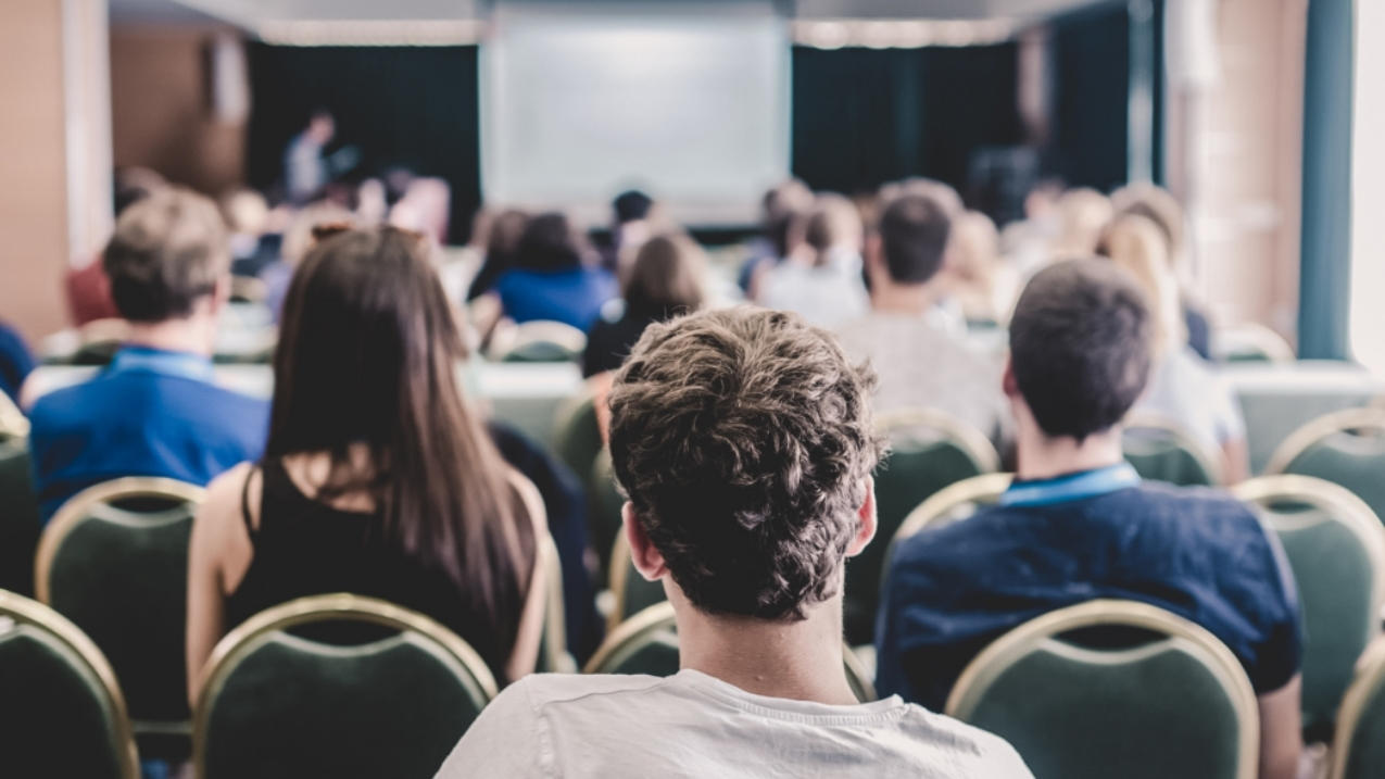 A group of persons listening to a panel.