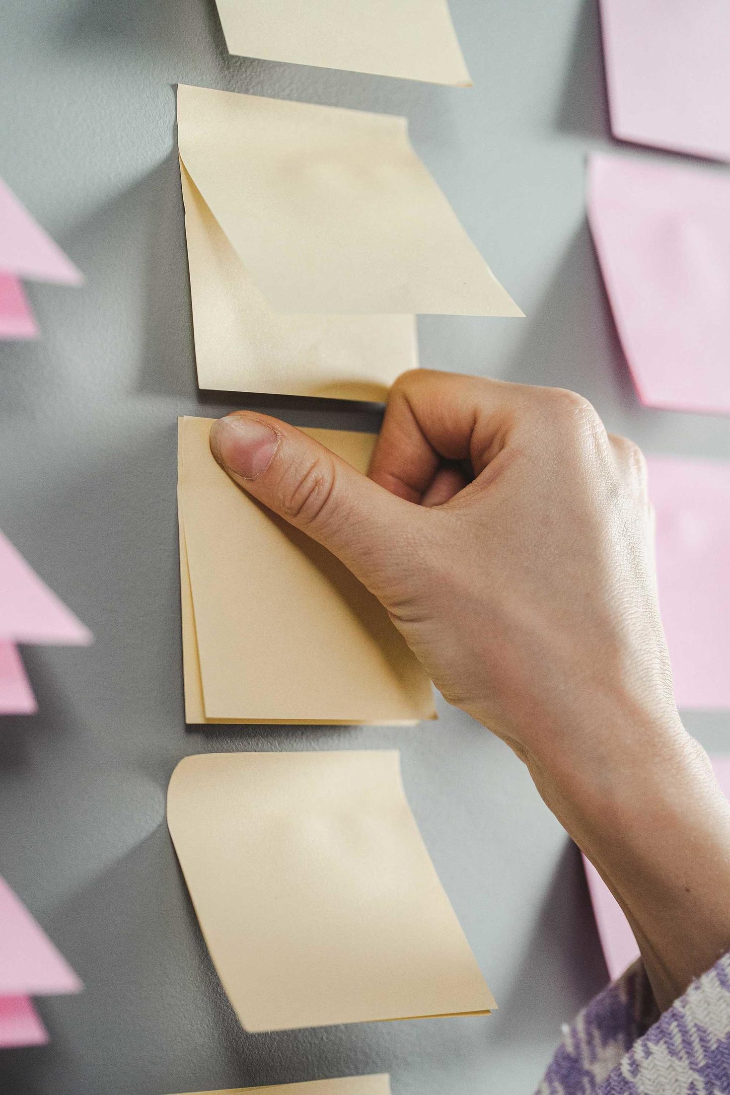 someone sticking a post-it on the wall