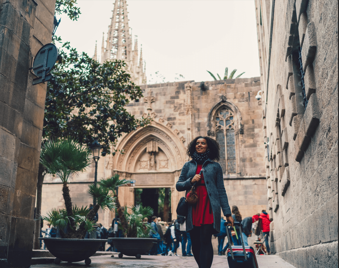 Girl walking through Barcelona with a suitcase
