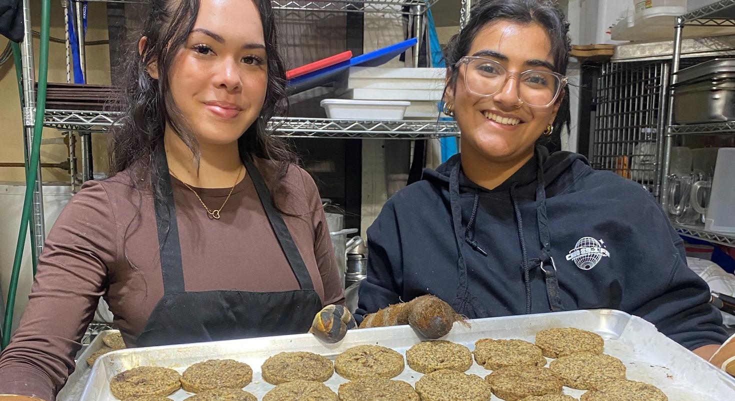 Two students show a tray of cookies.
