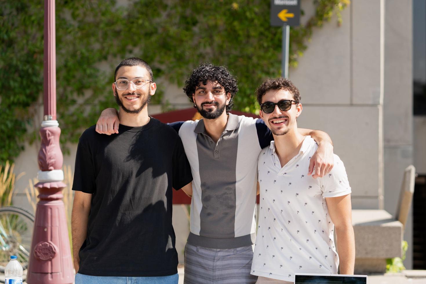 Three student members of a club stand arm in arm together at the 2023 Club Fair at the University of Ottawa.