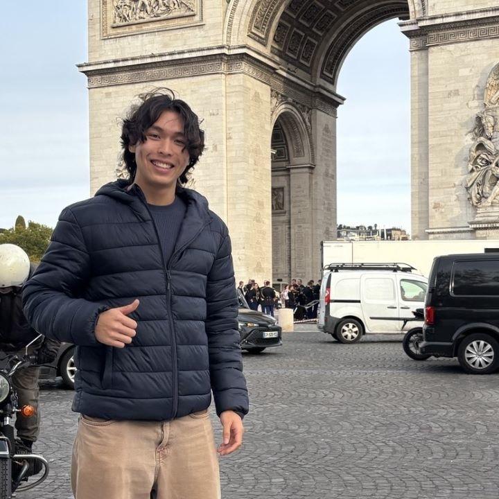 Bowen Zhang gives a thumbs up in front of an ornate arc on the streets in Mannheim, Germany.