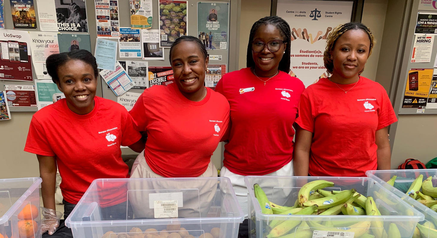 Volunteers with the University of Ottawa Student Union's free produce market, Myrie H' Jac, Melissa Wenza Pageot, Iman Olivia Louré, Calynne Niyonziza, pose in front of containers filled with plantains.