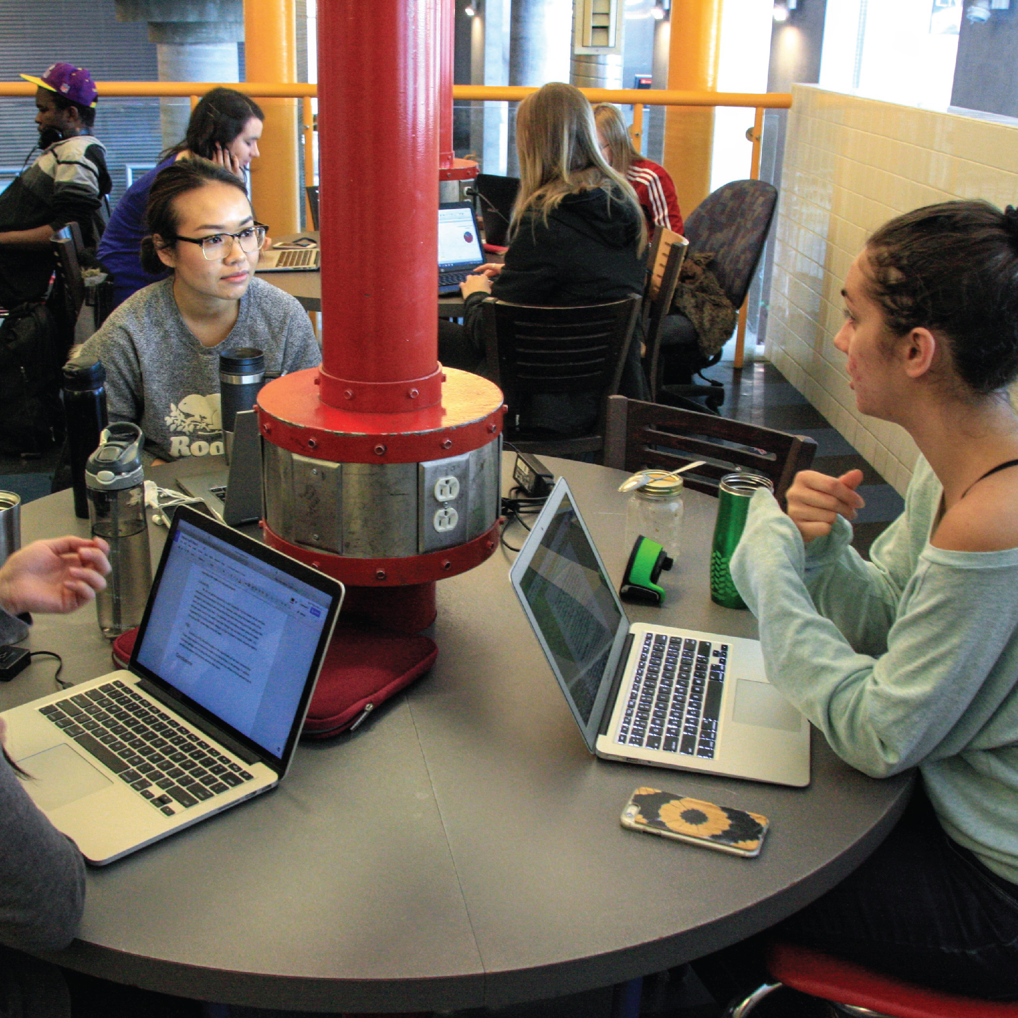 Étudiantes de l’Université d’Ottawa travaillant avec des ordinateurs portables déposés sur une table