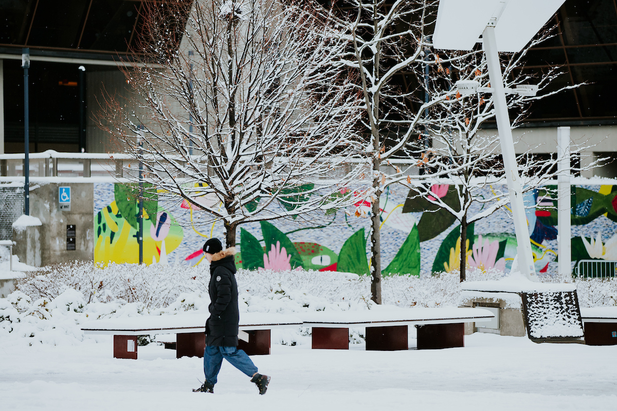 Une personne marchant sur le campus en hiver