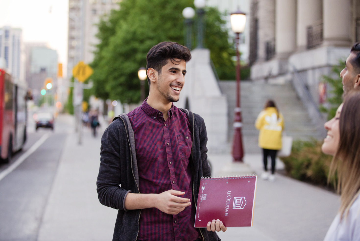Étudiant avec un livre arborant le logo uOttawa.