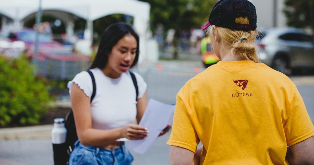 Étudiant qui aide une étudiante sur le campus.