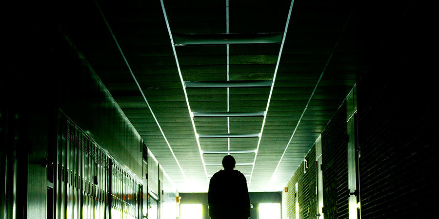 Personne marchant dans un couloir sombre.