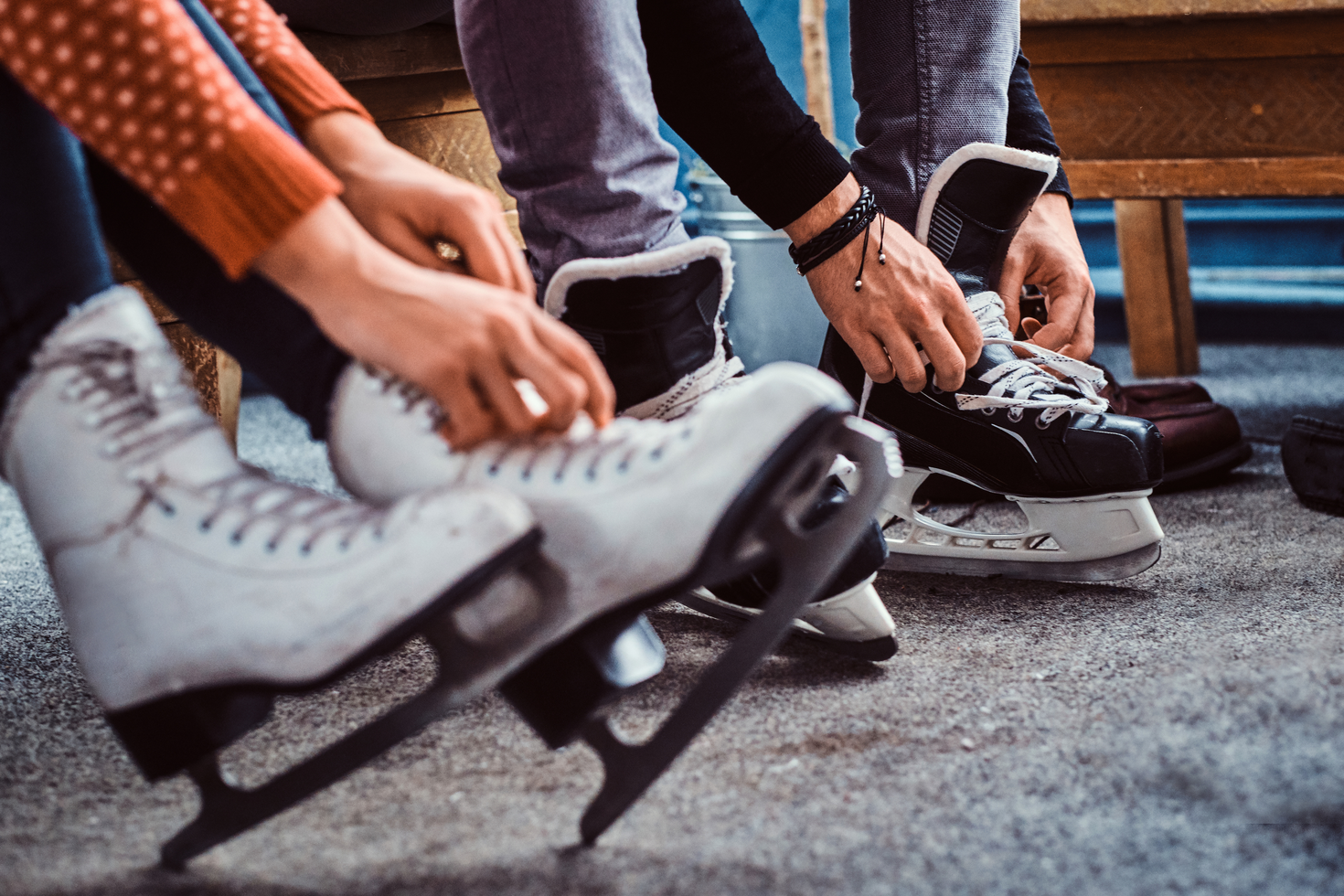 Two people putting on their skates