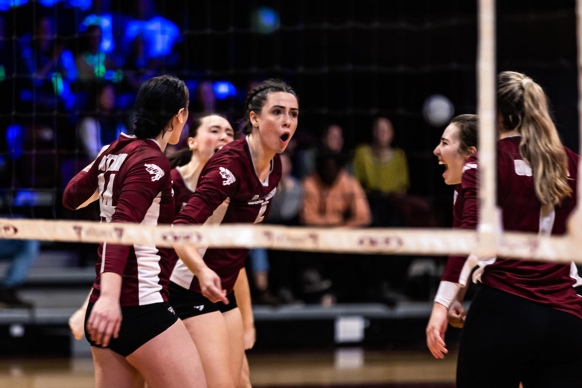 volleyball players cheering with fans glowing in background
