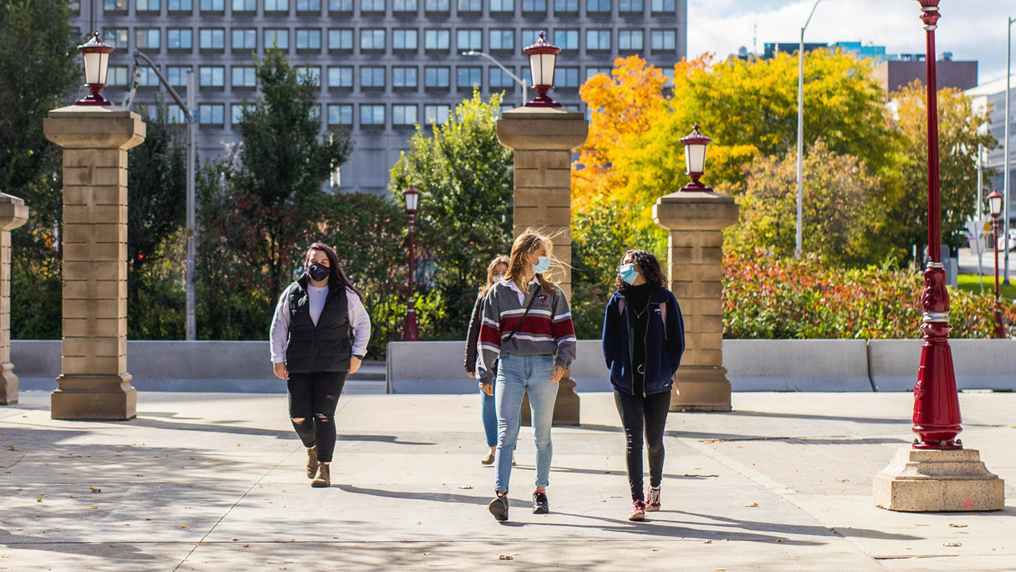 students with masks walking on campus