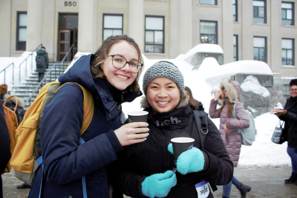 des étudiantes dehors à l'hiver buvant du chocolat chaud
