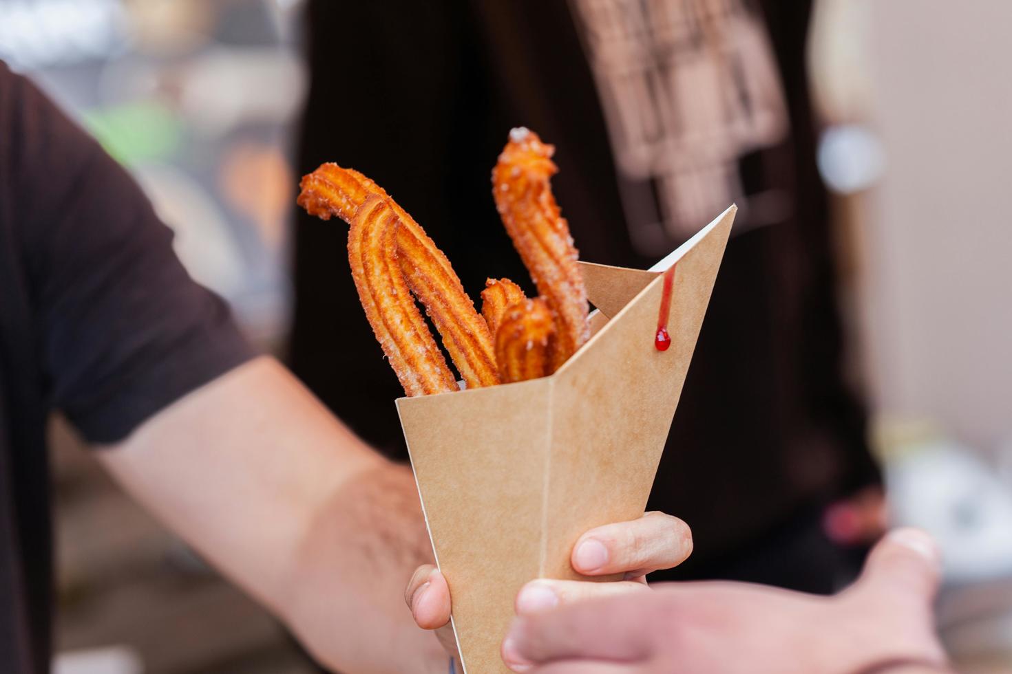 Des mains qui porte des churros