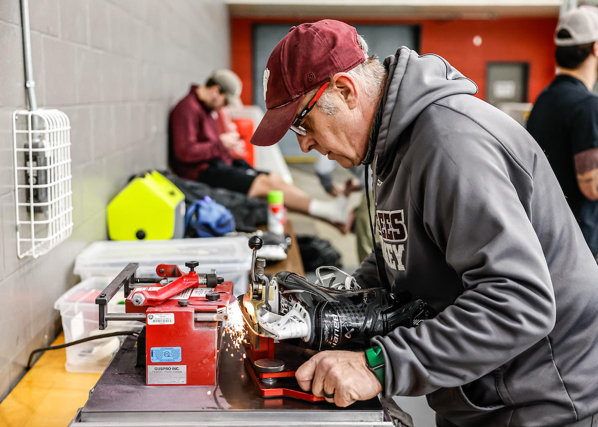 une personne qui affute des patins d'hockey