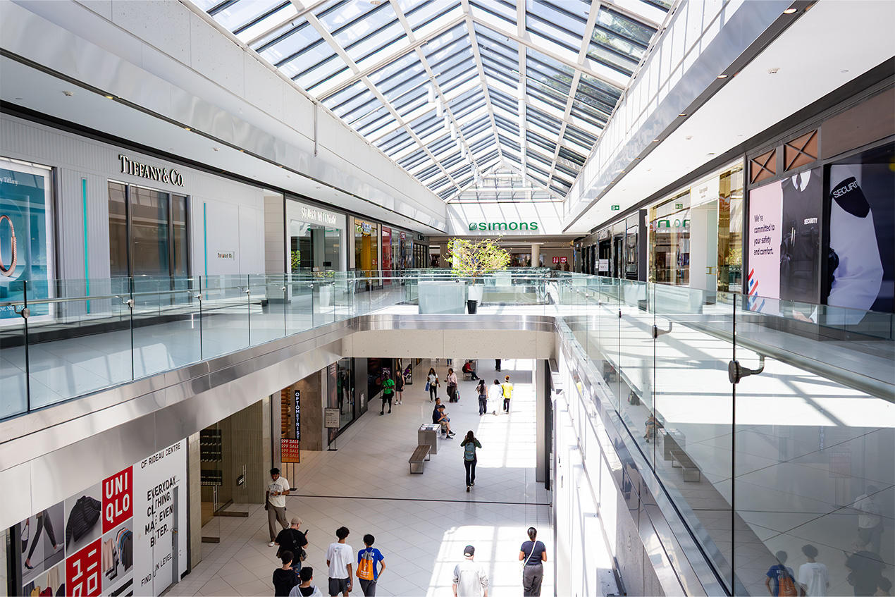 Deux étages de boutiques sous une verrière triangulaire au Centre Rideau.