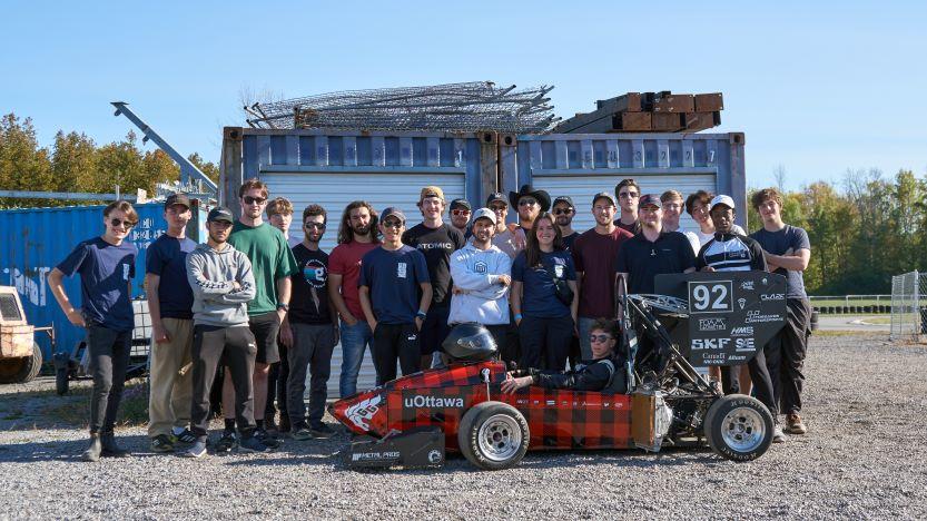 Les membres du club Formula uOttawa posent à côté de leur petite voiture de course..