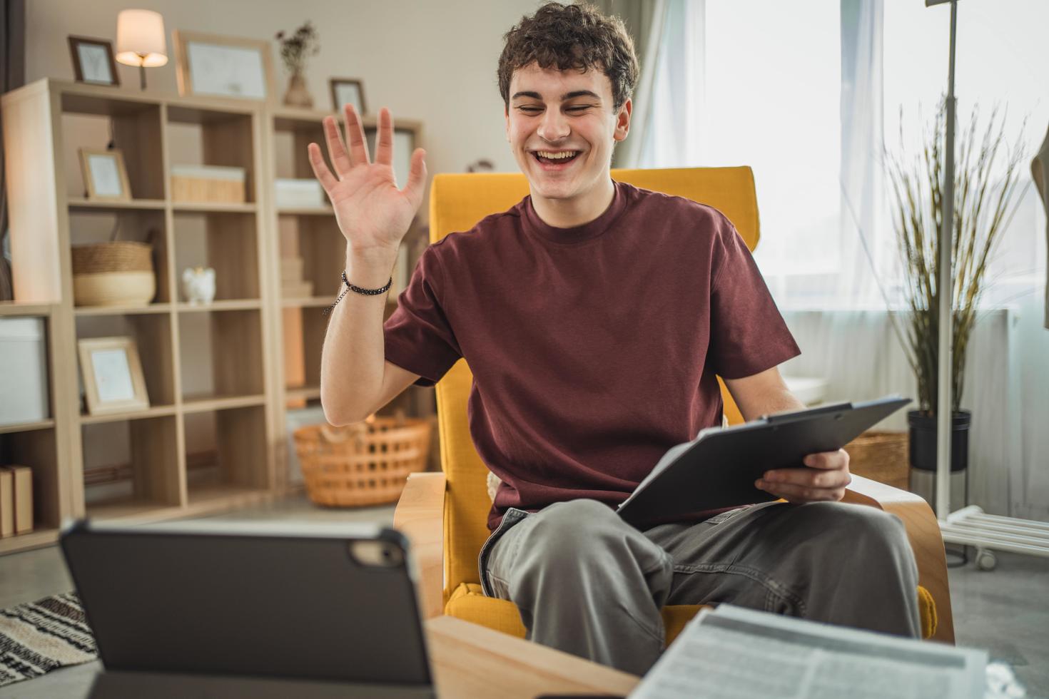 Jeune homme en train de rire devant son laptop