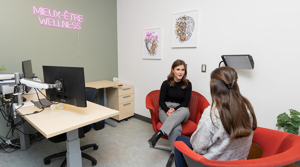 Une étudiante assise avec un conseiller.