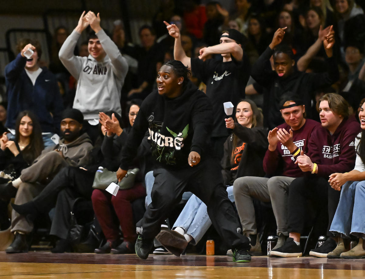 Des partisans encouragent les joueurs au bord du terrain lors d'un match de basketball des Gee-Gees.