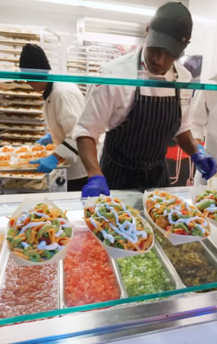 un employé qui sert des repas à la salle à manger