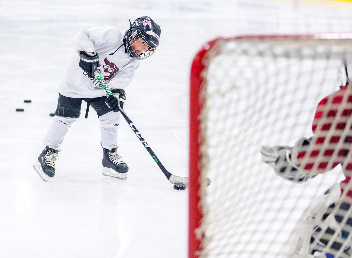 enfant qui tire la rondelle dans le filet de hockey