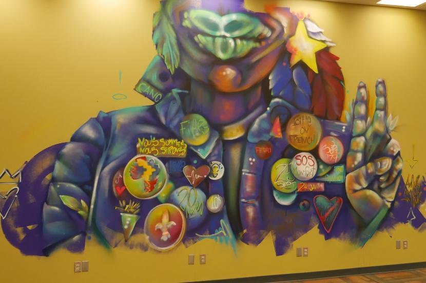 La fresque « French Kiss » montre la tête et les épaules d’une personne portant plusieurs insignes sur sa veste.